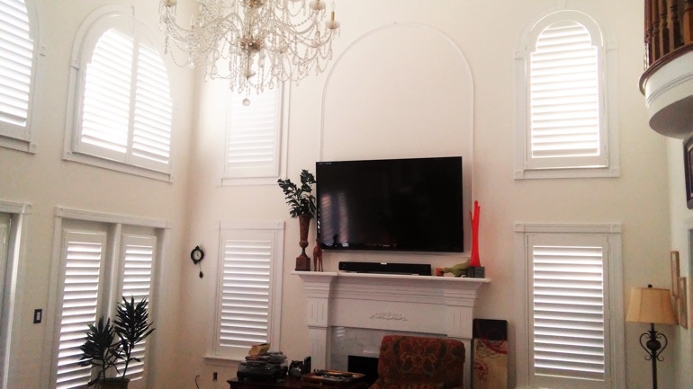 Orlando great room with mounted TV and arched windows.